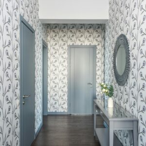 A stylish hallway featuring floral wallpaper, a console table, and a decorative mirror.